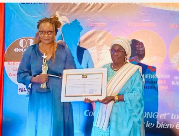 Légende: La Coordonatrice nationale du Burkina Faso, Mme Octavie Noellie Neya/OUEDRAOGO (à gauche) reçoit le prix au nom de l’ONG Stand for Life and Liberty.