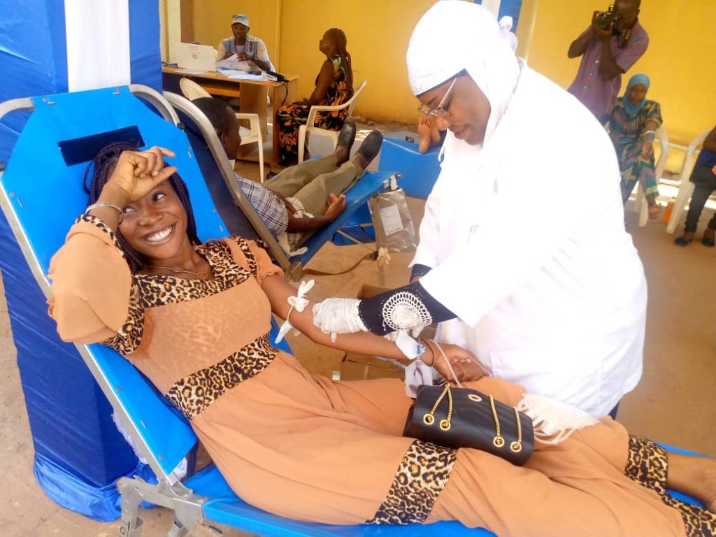 Samira ZARE de la rédaction du media en ligne Burkina 24 en train de donner son sang avec sourire 