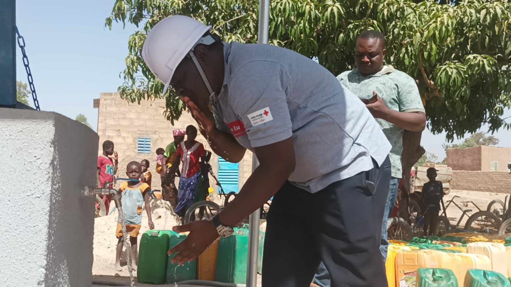 Ayouba Yaguibou, chef des projets Croix-Rouge burkinabè Croix-Rouge Luxembourgeoise, consommant l'eau potable issue de la borne fontaine N° de Sané