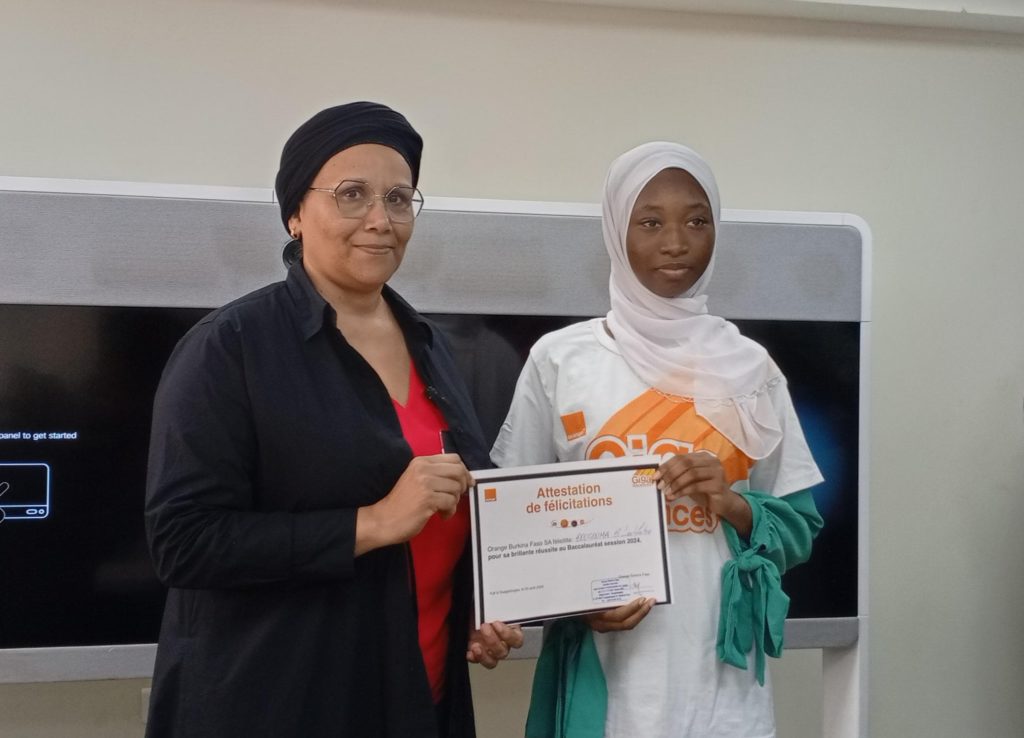 La Directrice Générale de Orange Burkina Faso, Nafy Silue Coulibaly remettant l'attestation de Bénewendé Latifatou Bougma , 2e au BAC C avec 17,88 de moyenne 