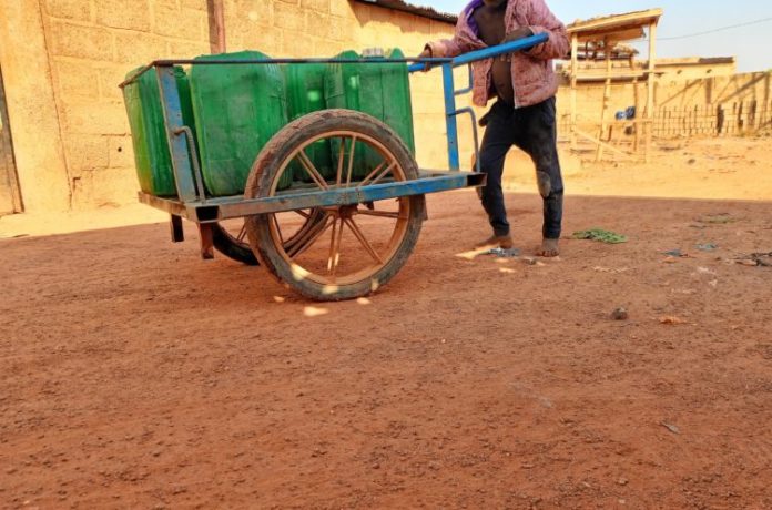 Le petit Jacob traînant ses bidons/photo © Burkina24 