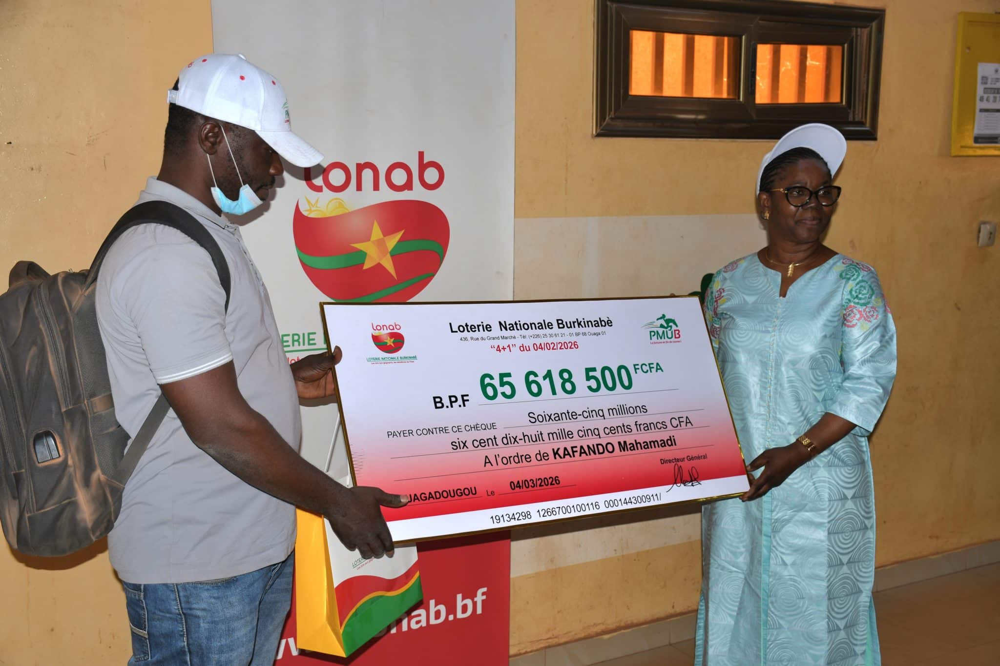 Mahamadi Kafando recevant son chèque de 65 618 500 F CFA à l'agence LONAB Ouaga 3.