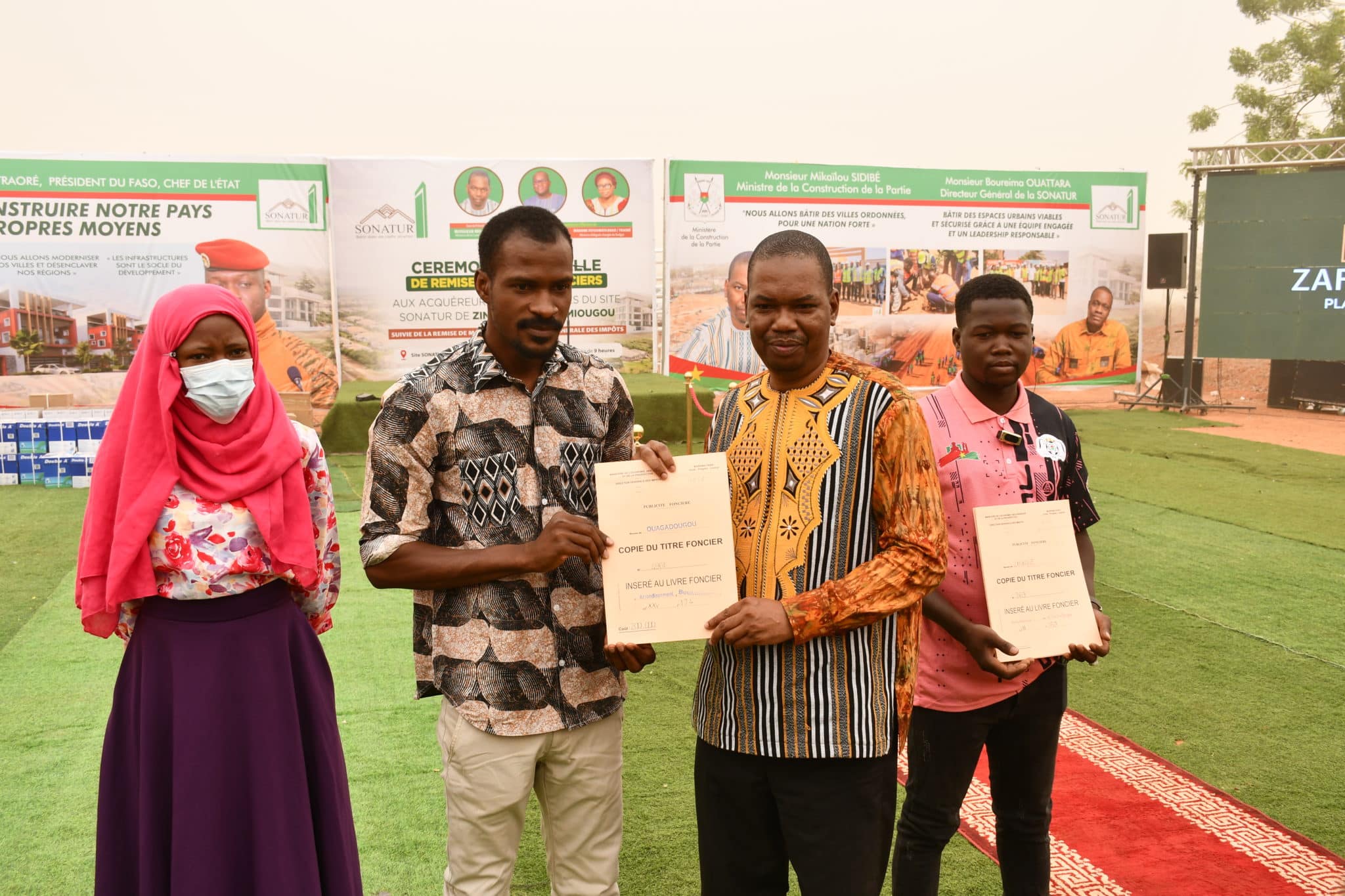 Le Ministre de la Construction remettant symboliquement un titre foncier à l'un des 500 bénéficiaires des sites de Ziniaré et Silmiougou