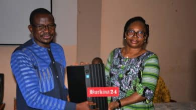 Remise symbolique de matériel informatique par la ministre déléguée chargée de l’Économie au Pr Moumouni Zoungrana lors du lancement de la campagne.