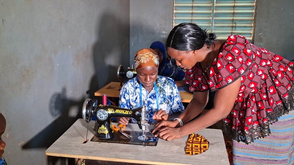 Odile reçoit les consignes de son encadreuse lors d'un atelier pratique de coupe-couture. ©Burkina 24, Mai 2026