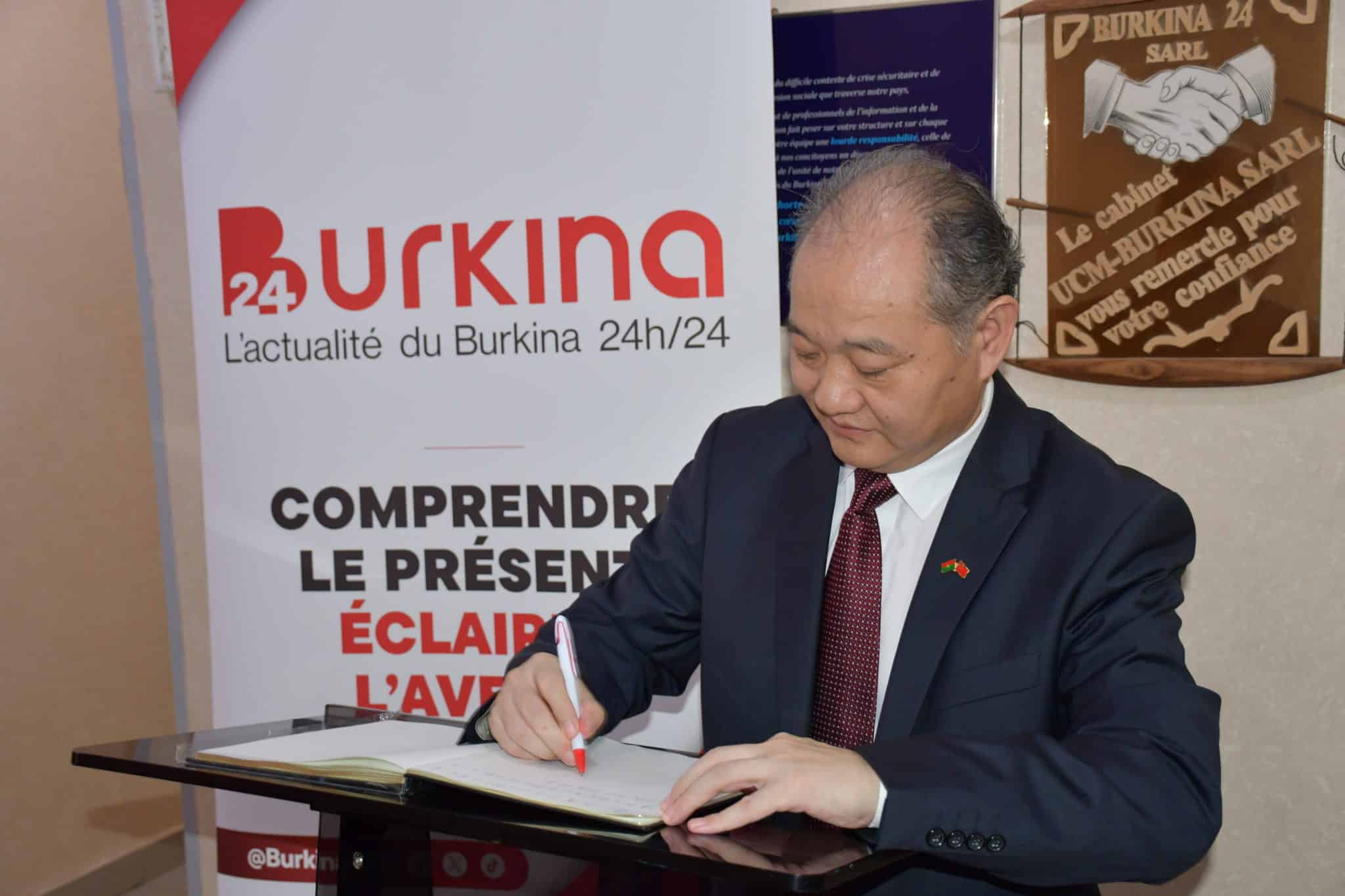 Son Excellence Monsieur l’Ambassadeur de Chine au Burkina Faso, ZHAO Deyong, signe le livre d’or de Burkina 24 à l’occasion de la célébration du 15ᵉ anniversaire du média