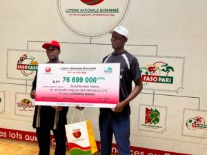 Issaka Koanda, tapissier recevant son chèque de Yamba Jean Zida, directeur de l'exploitation des jeux de la LONAB
